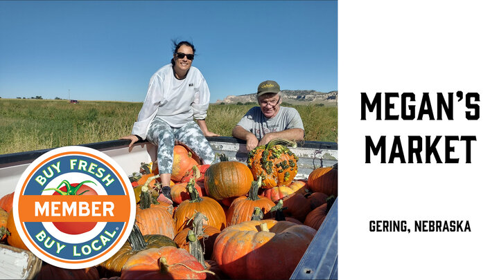 Tracy and daughter, Megan, showcasing their pumpkin harvest